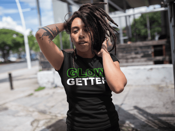 Female with dreads, Tattoos and nose rings wearing a Black T-shirt with Glow Getter on the front available from the Xpert Apparel Store 