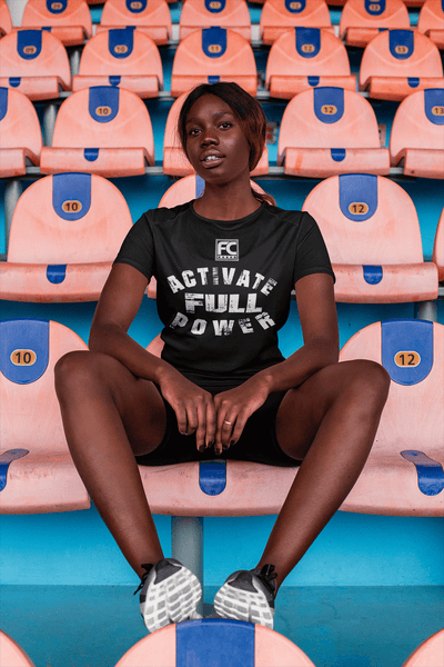 Woman working out in stadium taking a break  wearing t-shirt  with Activate Full Power design on the front available from the Xpert Apparel Store 